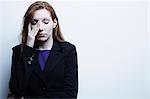 Studio portrait of young businesswoman rubbing eyes