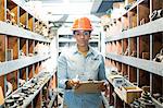 Young woman in warehouse with clipboard