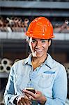 Woman in warehouse holding smartphone