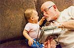 Grandfather playing with baby granddaughter