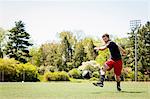 Soccer player running and kicking ball