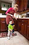 Young male toddler and grandmother in kitchen