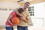 Brother with sister in head lock holding basketball