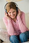 Mature woman wearing headphones, smiling
