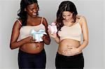 Two pregnant women with pink and blue gift boxes