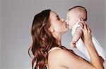 Mother kissing baby daughter