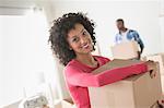 Mid adult woman carrying cardboard boxes