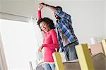 Mid adult couple dancing in new home