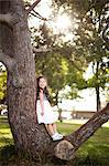 Portrait of girl standing on tree trunk