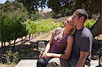 Young couple in vineyard, woman with white wine