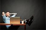 Man sitting back with legs on table