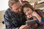 Father and daughter looking at digital tablet