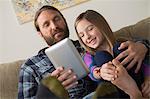 Father and daughter looking at digital tablet