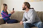 Daughter photographing father with smartphone