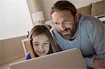 Father and daughter looking at laptop