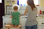 Mother and child at kitchen sink