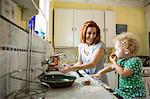 Mother at sink smiling at child