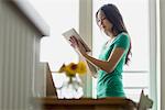 Woman holding up and using digital tablet