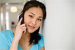 Woman leaning head against wall on phone