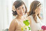 Smiling woman with flower looking at camera