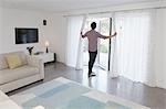 Man looking out of glass door