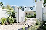 Driveway with open gate to luxury house