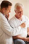 Doctor checking senior man's heart with stethoscope