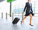 Businesswoman running with suitcase