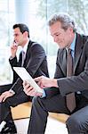 Businessman using digital tablet in lobby