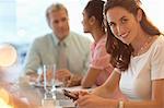 Portrait of smiling businesswoman with cell phone in meeting