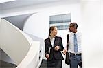 Businessman and businesswoman talking on modern staircase