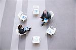 High angle view of businessman and businesswoman talking at chairs in circle