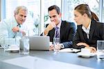 Business people sharing laptop in meeting