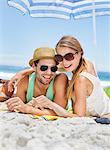 Portrait of smiling couple laying on beach