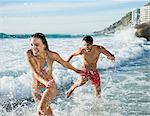 Playful couple splashing in ocean surf