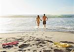 Couple holding hands and wading in ocean