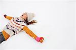 Enthusiastic woman making snow angel