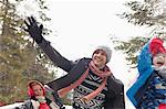 Playful father and sons throwing snow