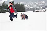 Mother and sons playing in snowy field