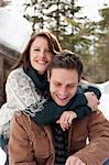 Portrait of hugging couple outside snowy cabin