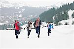 Family running in snowy field