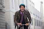 Enthusiastic businessman riding bicycle in rain