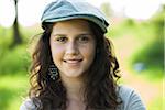 Close-up portrait of teenaged girl wearing cap outdoors, smiling and looking at camera, Germany