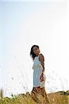 Portrait of teenaged girl standing in field on summer day, looking at camera, Germany