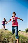 Girls running in field, Germany