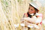 Portrait of Girl wearing hat, sitting in field, Germany