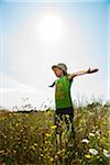 Girl standing in field with arms outstretched, Germany