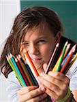 Close-up of girl holding colored pencils in hands, Germany