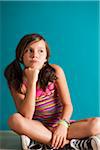 Portrait of girl sitting on floor, pouting, Germany