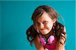 Portrait of girl wearing headphones around neck, looking at camera, making funny faces, Germany